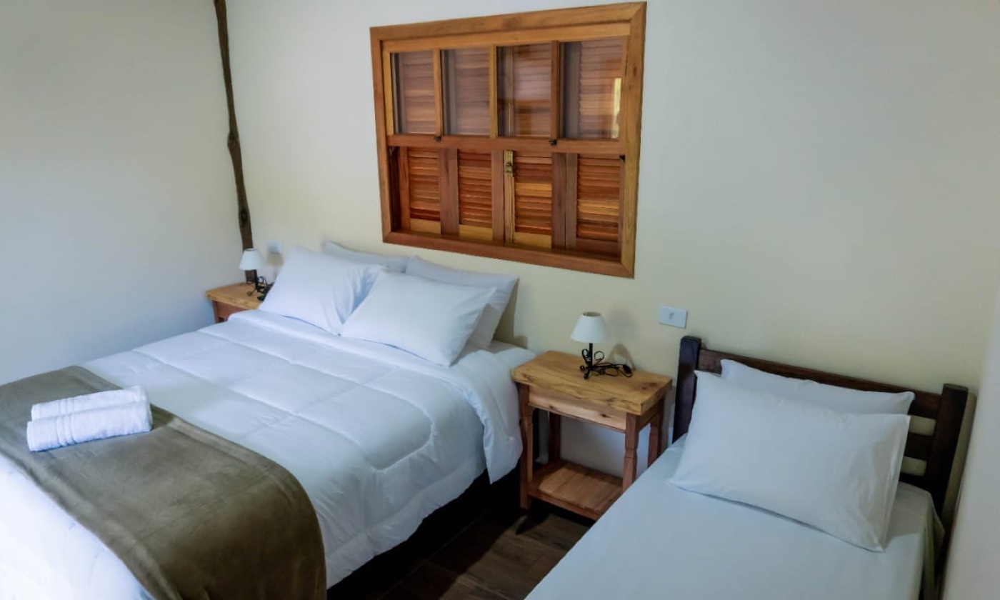 Quarto com janela de madeira para o verde