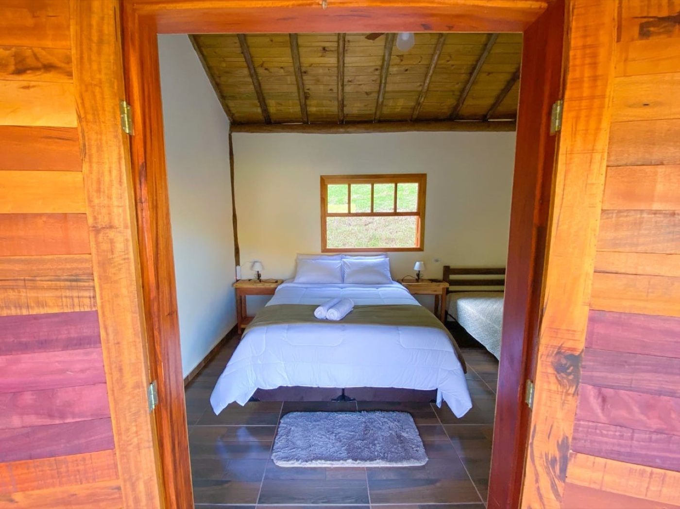 Quarto com teto de madeira e cama extra