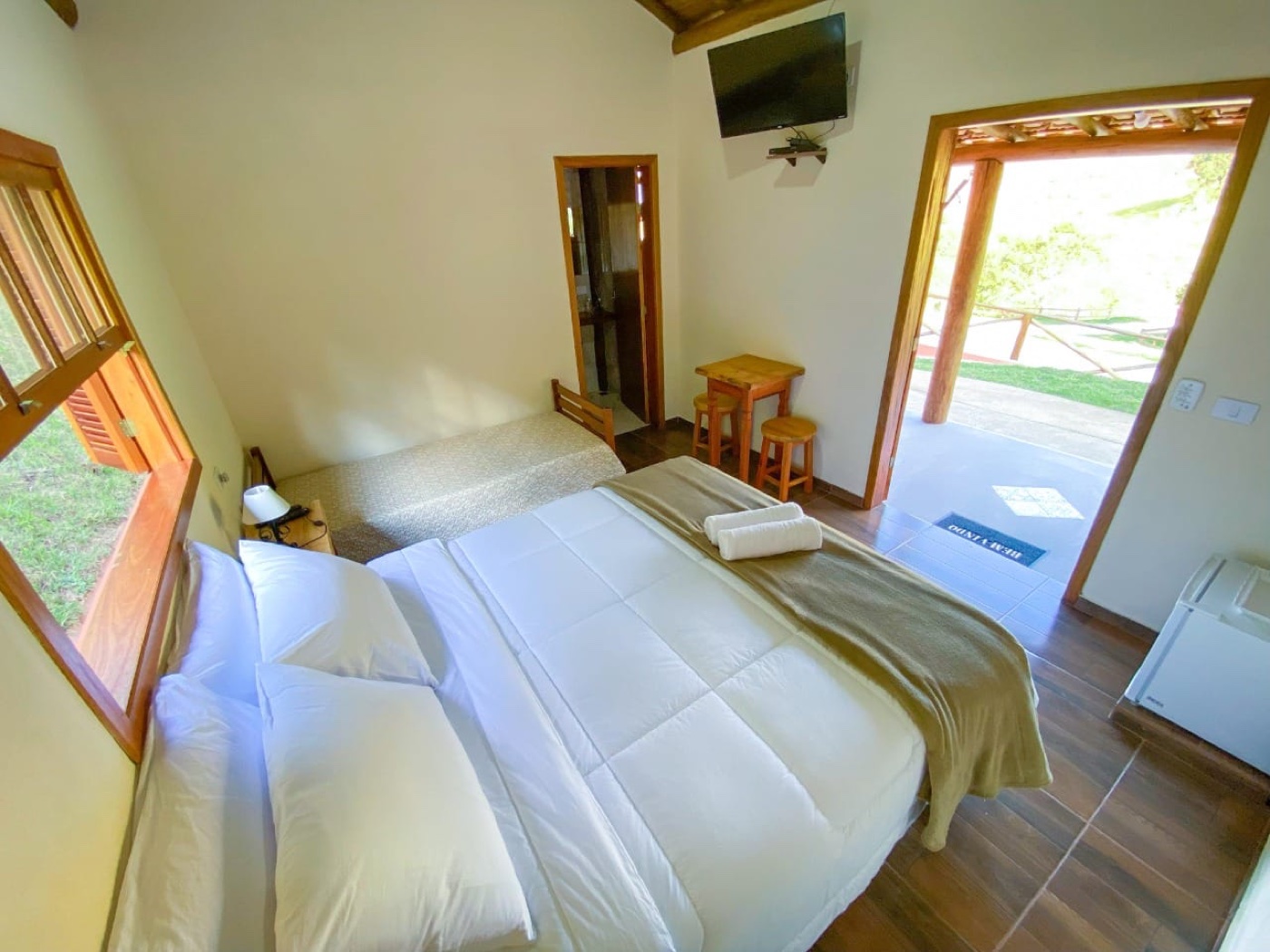 Quarto amplo com TV e porta para a varanda